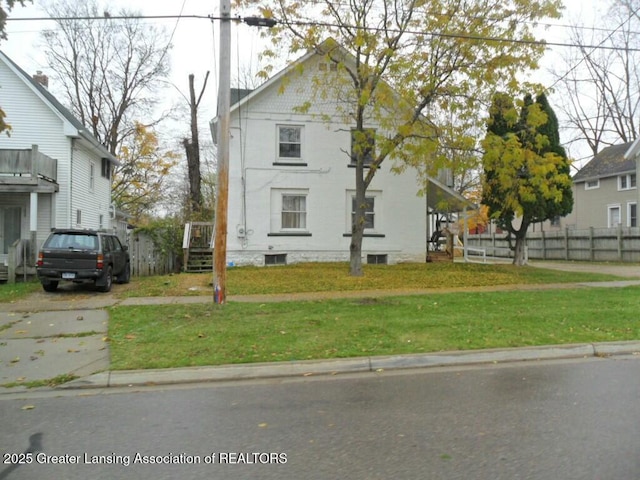 view of front of property featuring a front lawn and fence