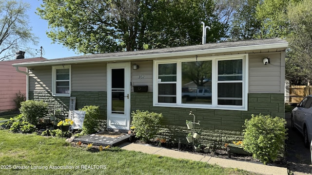 302 E Monroe St, Jackson, MI 49202 - bungalow-style home featuring a front lawn and stone siding