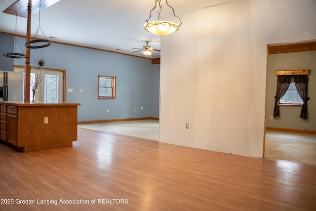 interior space with ornamental molding, ceiling fan, and light wood-type flooring