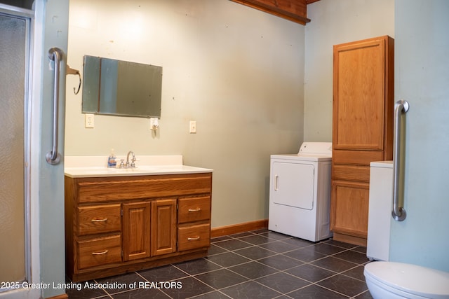 bathroom with vanity, washer / dryer, and tile patterned floors