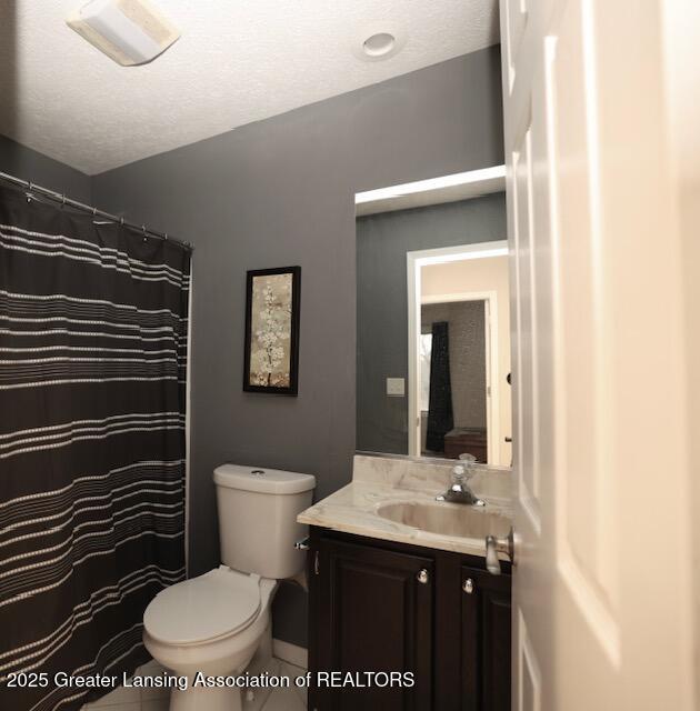 bathroom featuring vanity, toilet, and a textured ceiling