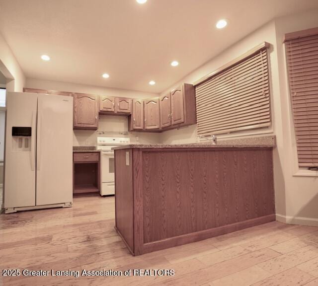 kitchen featuring white appliances and light hardwood / wood-style floors