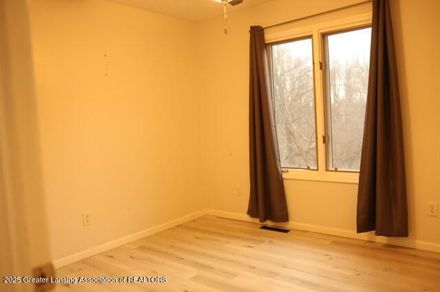 spare room with hardwood / wood-style flooring and a wealth of natural light