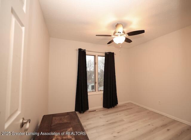 empty room featuring ceiling fan and light hardwood / wood-style flooring