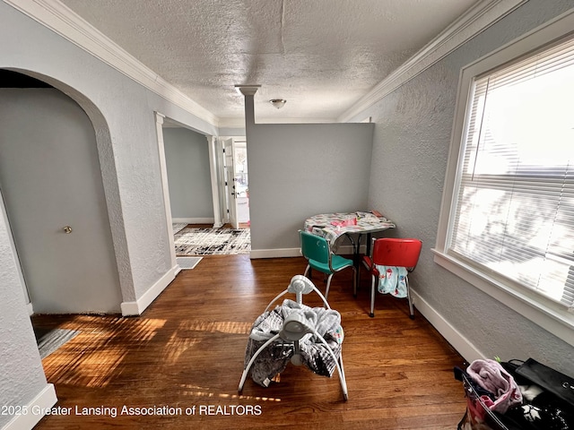 dining area featuring dark hardwood / wood-style flooring, crown molding, and a wealth of natural light