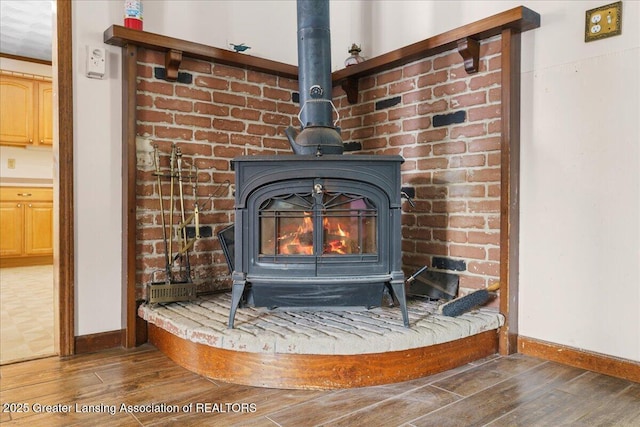 details with a wood stove and hardwood / wood-style floors