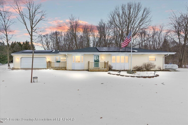 view of front of home with a garage and solar panels