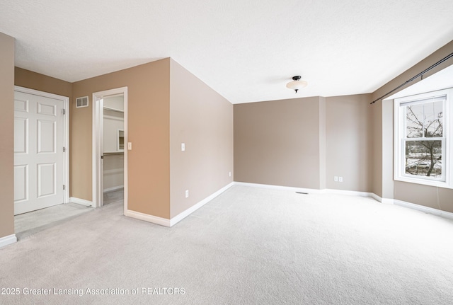 carpeted spare room with a textured ceiling