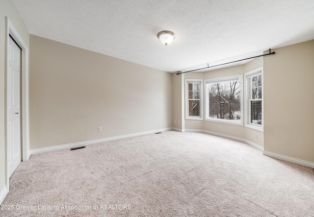 carpeted spare room featuring a textured ceiling