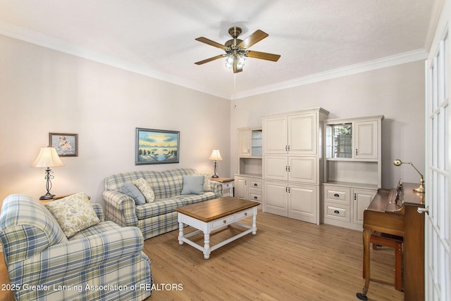 living room featuring ornamental molding, ceiling fan, and light hardwood / wood-style flooring