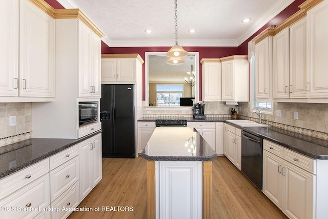 kitchen with a kitchen island, sink, hanging light fixtures, light hardwood / wood-style floors, and black appliances