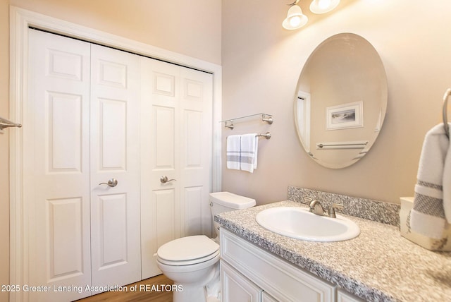 bathroom featuring hardwood / wood-style flooring, vanity, and toilet