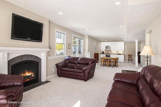 carpeted living room with a tile fireplace and a textured ceiling