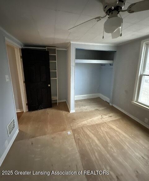 unfurnished bedroom with ceiling fan and wood-type flooring