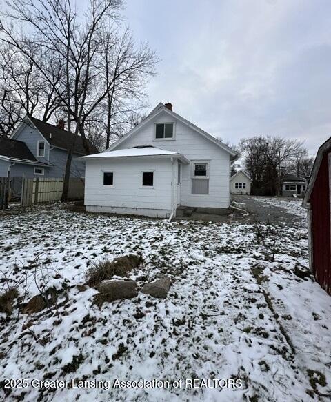 view of snow covered rear of property