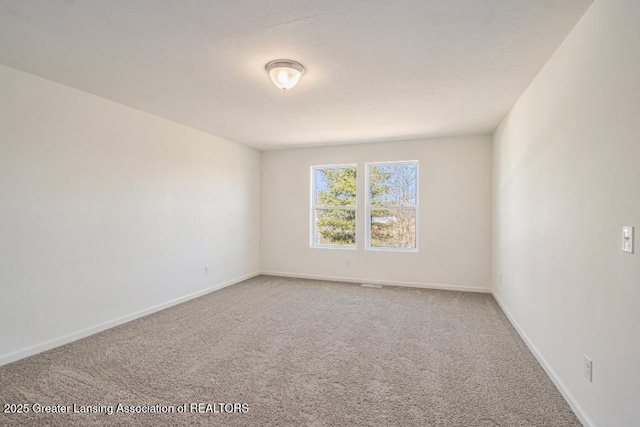 empty room featuring carpet flooring and baseboards