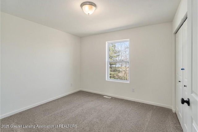 unfurnished bedroom with carpet flooring, baseboards, and a closet