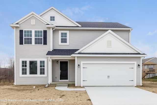 traditional-style home with an attached garage, concrete driveway, and a shingled roof