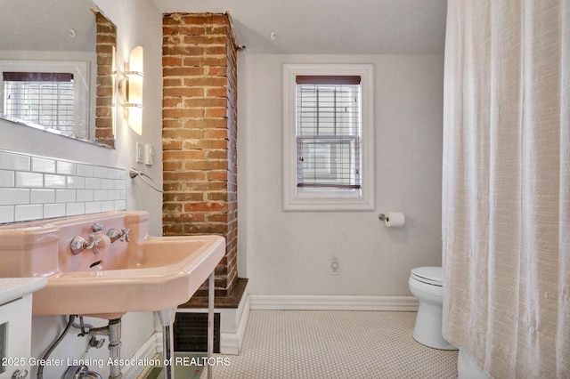 bathroom featuring tasteful backsplash, tile patterned floors, and toilet