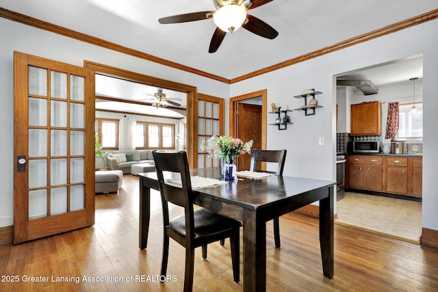 dining area featuring crown molding and light hardwood / wood-style flooring