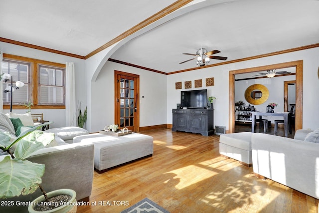 living room featuring hardwood / wood-style flooring, ceiling fan, and crown molding