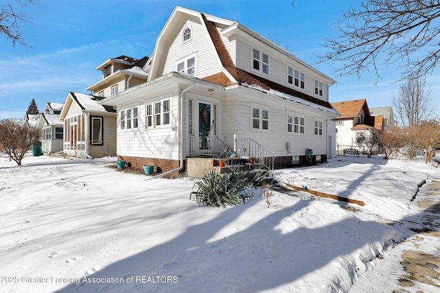 view of snow covered back of property