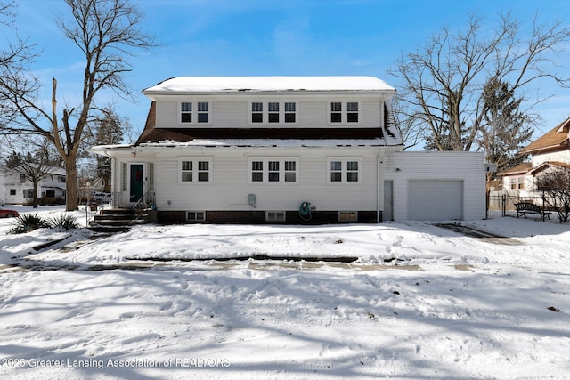 snow covered house with a garage