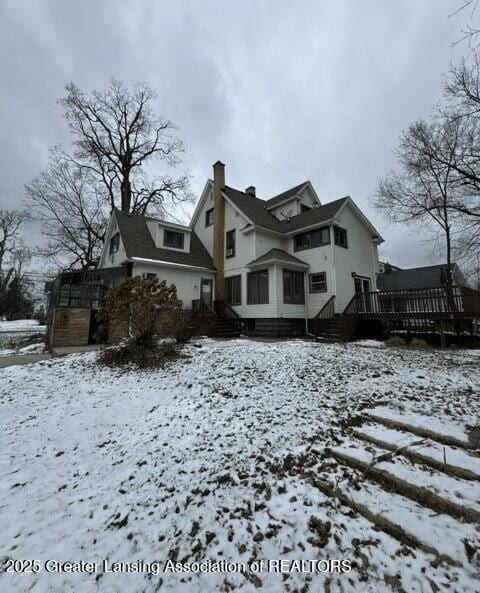 snow covered property with a deck