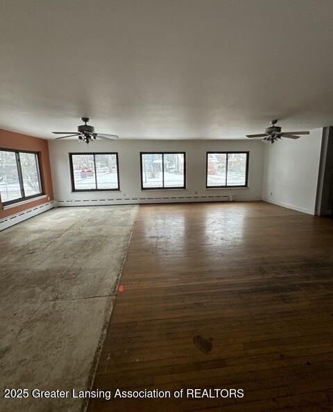 unfurnished room featuring dark hardwood / wood-style flooring, plenty of natural light, and ceiling fan