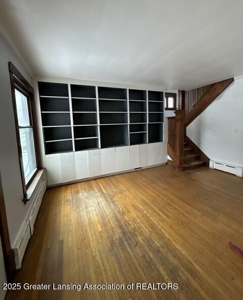 empty room with wood-type flooring and baseboard heating