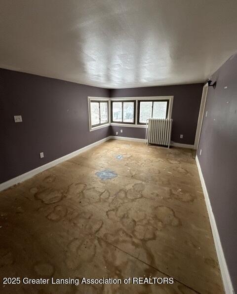 interior space featuring radiator heating unit and concrete flooring