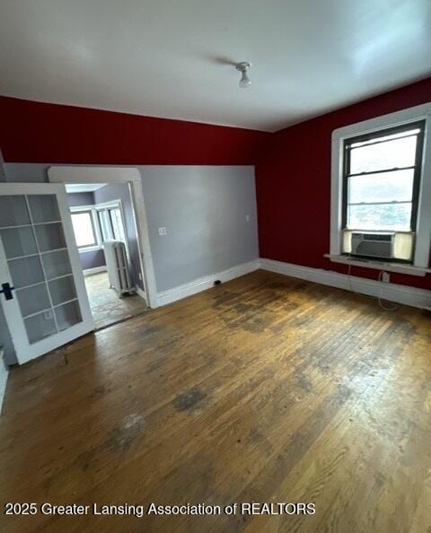 spare room with cooling unit, plenty of natural light, and hardwood / wood-style flooring