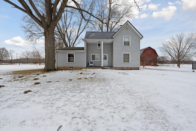 view of snow covered rear of property