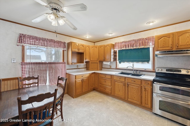 kitchen featuring range with two ovens, ornamental molding, sink, and ceiling fan