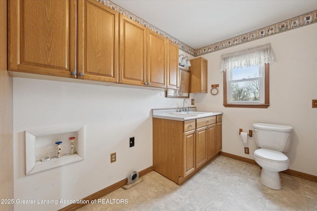 clothes washing area featuring washer hookup, sink, and cabinets