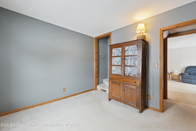 foyer entrance featuring light carpet and a textured ceiling