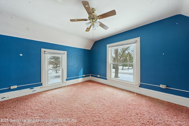 unfurnished room with vaulted ceiling, a healthy amount of sunlight, and carpet