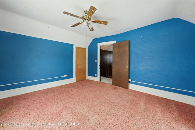 empty room featuring lofted ceiling, carpet floors, and ceiling fan