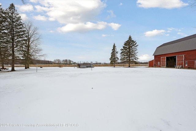 yard covered in snow with an outbuilding