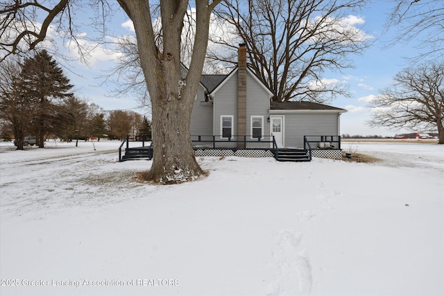 snow covered house with a deck