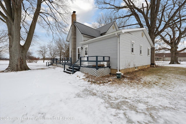 view of snowy exterior with a deck