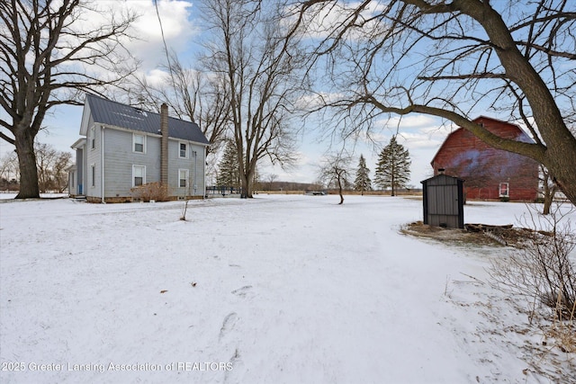 yard layered in snow with a storage shed