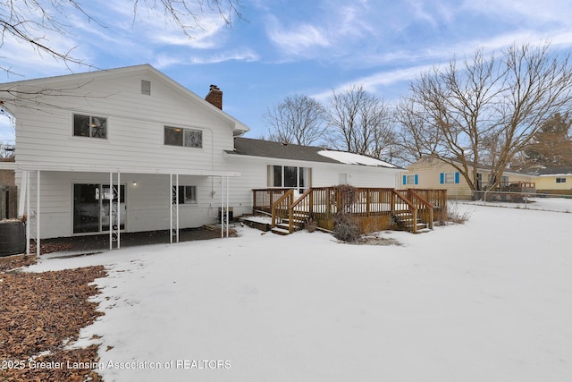 snow covered property featuring cooling unit and a wooden deck