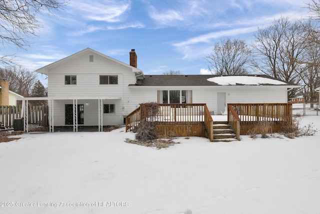 snow covered house featuring a wooden deck