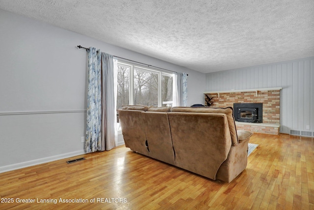 living room with light hardwood / wood-style floors and a textured ceiling