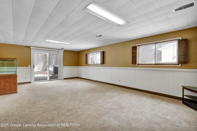 spare room with light colored carpet and a healthy amount of sunlight