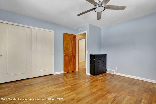 unfurnished bedroom with ceiling fan, light hardwood / wood-style floors, and a closet