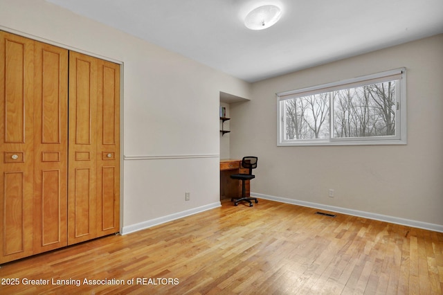 unfurnished bedroom featuring light hardwood / wood-style floors and a closet