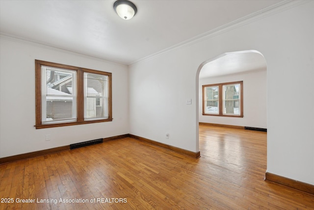 empty room featuring crown molding and light hardwood / wood-style floors