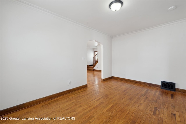 spare room featuring crown molding and hardwood / wood-style floors